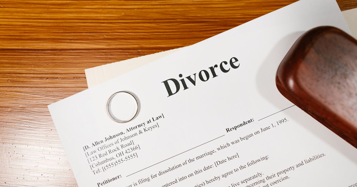 Divorce paperwork and a wedding ring lying on a desk