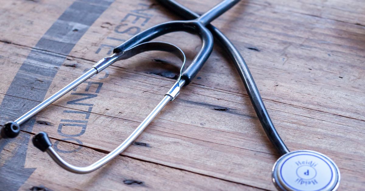 A stethoscope lying on a wooden table