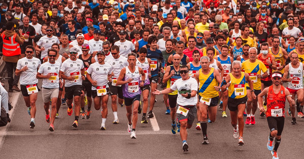 A large group of runners on a city road during a road race